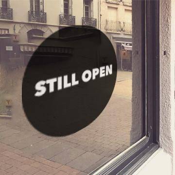 Black window cling with white "Still open" lettering - FoodSignPros