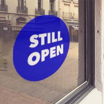 Blue window cling with white "Still open" lettering - FoodSignPros