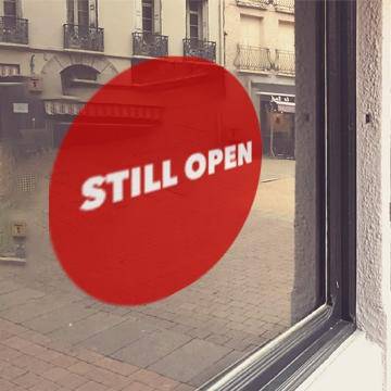 Red window cling with white "Still open" lettering - FoodSignPros